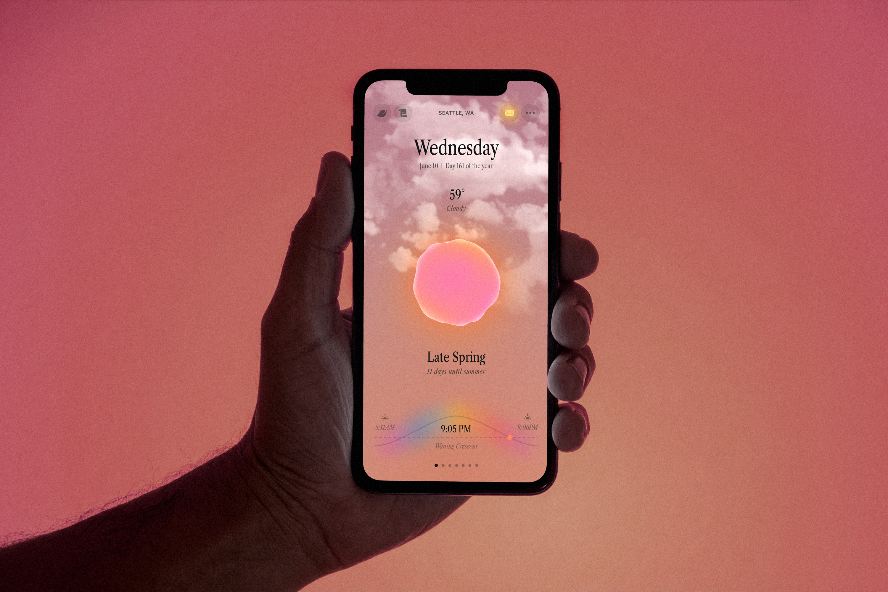 Hand holding an iPhone displaying Ambient Almanac